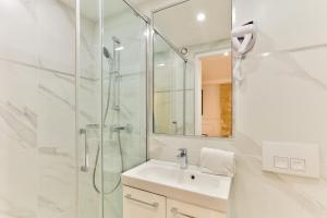 un bagno bianco con lavandino e doccia di 113 - Urban Vuitton Lemoine a Parigi Altre 20 foto