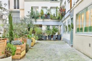 cortile con piante in vaso sul lato di un edificio di 113 - Urban Vuitton Lemoine a Parigi