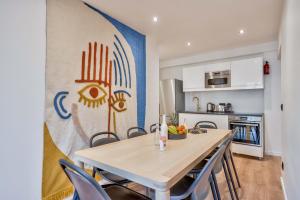 - une cuisine et une salle à manger avec une table et des chaises dans l'établissement 102 - Urban Opera Picasso, à Paris
