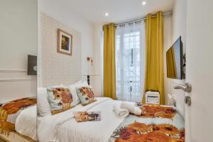 a bedroom with a bed and a window with yellow curtains at 107 - Urban Luxury Opera Vinci in Paris