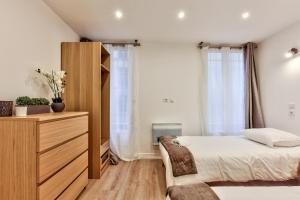 um quarto com uma cama, uma cómoda e uma janela em 14 Luxury Flat Eiffel Design 1 em Paris