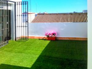 un balcone con prato verde e fiori su un edificio di One bedroom apartement with sea view furnished terrace and wifi at El Puerto de Santa Maria 2 km away from the beach a El Puerto de Santa María