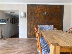 a dining room with a wooden table and chairs at Hotel Die Friesenhalle in Bredstedt