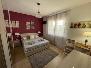 1 dormitorio con cama y pared roja en Beppo's B&B, en Carbonia