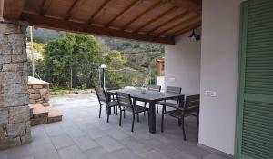 eine Terrasse mit einem Tisch und Stühlen auf einer Terrasse in der Unterkunft VILLETTA LA ZANCA in Zanca