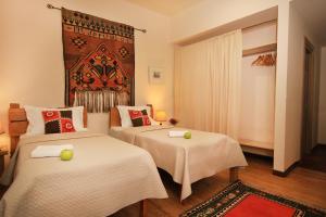 Habitación con 2 camas y una gran pintura en la pared. en Silk Road Hotel en Ereván