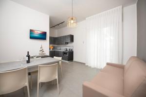 a kitchen and living room with a table and a couch at Residence OndaMare in Cervia