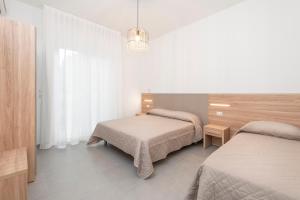 a bedroom with two beds and a chandelier at Residence OndaMare in Cervia