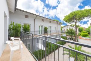 a balcony with two white chairs on it at Residence OndaMare in Cervia