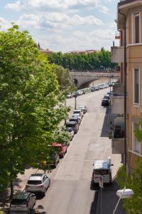 La Mansarda Segreta Mood Apartment في فيرونا: اطلالة على شارع فيه سيارات متوقفة وجسر