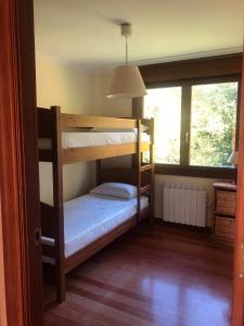 two bunk beds in a room with a window at Arroes Village And Pool - Villa con piscina privada in Villaviciosa
