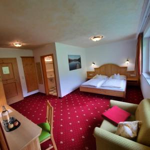 pokój hotelowy z łóżkiem i kanapą w obiekcie Landhaus Gastein w mieście Dorfgastein