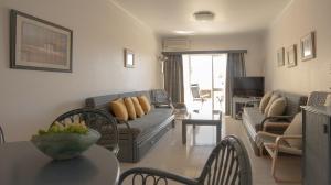 una sala de estar con un sofá y una mesa en Palmeira Gale - WIFI - Pool - Lux - BY BEDZY, en Albufeira