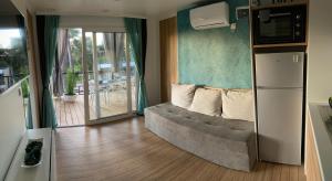 salon z kanapą przed balkonem w obiekcie Mobile Home DIVINA Camp Porton Nature Hideouts w Rovinj
