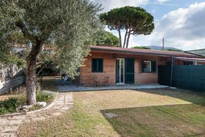 a brick house with a tree and a yard at Vivilo Collection - Chalet Mare - Private parking - Just 50 meters from the beach in Sperlonga