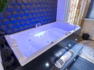 a tub in a bathroom with a blue wall at HOST INN - CŒUR VIEUX LYON & SPA in Lyon