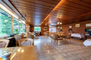 a restaurant with wooden ceilings and tables and chairs at Landhaus Jägerhof in Börnsdorf