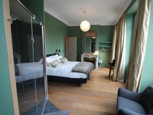 a bedroom with green walls and a bed and a mirror at B&B L'Escapade Bordelaise - Côté Jardin in Bordeaux