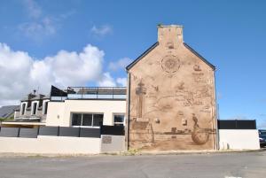 um edifício com um mural ao lado em Cap sur le Phare à Moguériec em Sibiril