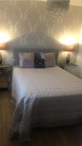 1 dormitorio con 1 cama blanca grande y 2 lámparas en Double room with en-suite. Central for North West en Rainhull