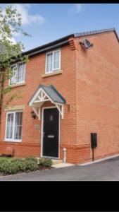 een rood bakstenen huis met een zwarte deur bij Double room with en-suite. Central for North West in Rainhill