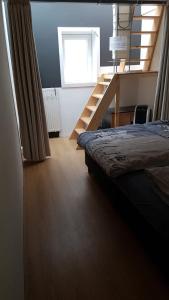 a bedroom with a bed and a staircase in a room at Whole building for yourself in Amsterdam