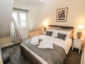 a bedroom with a bed with two swans on it at Globe Cottage in Stratford-upon-Avon