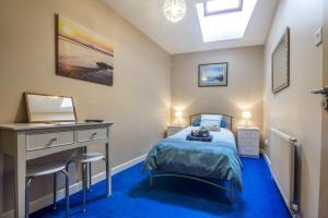 a bedroom with a bed and a desk and a mirror at Harry's - 2 Bedroom Holiday Home - Tenby in Tenby