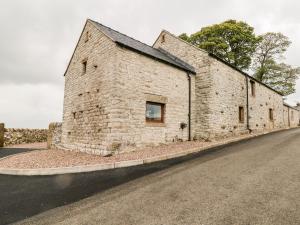 an old stone building on the side of a road at Owls Barn in Ashbourne