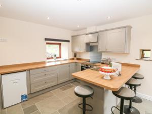 a kitchen with a table with a cake on it at Owls Barn in Ashbourne