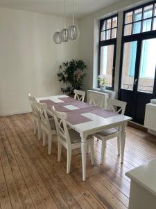 tavolo da pranzo bianco e sedie in camera di Casa Villa Borghese a Ostenda