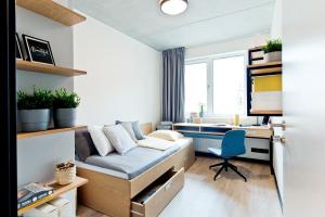 格但斯克MILESTONE Gdańsk Center的小房间设有一张床、一张桌子和一张书桌