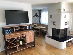 a living room with a flat screen tv and a fireplace at Renovated 3 Rooms Apartment in Ruschein near Laax in Ruschein