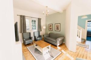 a living room with a couch and two chairs at Factors House - A comfy cottage in countryside park with WIFI and access to bar and pool in Perth