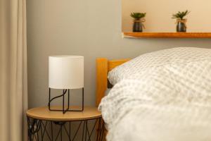 a lamp on a night stand next to a bed at Penzion De Monte in Horní Planá