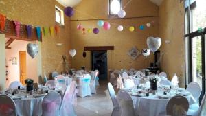 una stanza con tavoli e sedie bianchi e palloncini di Gîtes du Martroy a Nargis Altre 9 foto