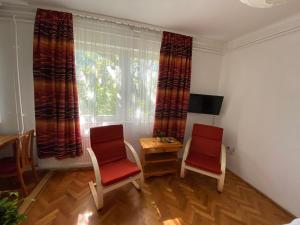 um quarto com duas cadeiras, uma mesa e uma janela em Anonymus Vendégház em Siófok