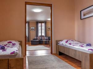 a bedroom with two beds and a living room at Apartmány V Mlýnské strouze in Pilsen