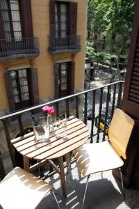 d'une table en bois et de deux chaises sur un balcon. dans l'établissement Colom Apartments, à Barcelone