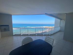 a room with a balcony with a view of the ocean at Sorgente 305 in Umdloti +6 photos