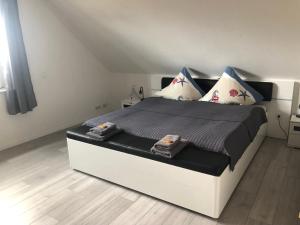 1 dormitorio con 1 cama blanca grande con almohadas en Am Anker, en Langballig