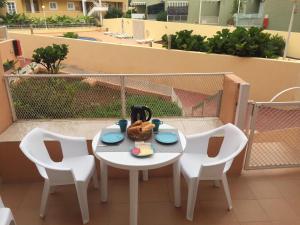 d'une table et de chaises blanches sur un balcon. dans l'établissement Orlando Adeje, à Adeje