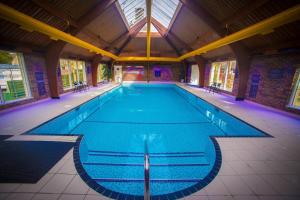 a large swimming pool in a large building at Atholl Apartment - A Unique apartment in countryside park with WIFI and access to pool and bar in Perth