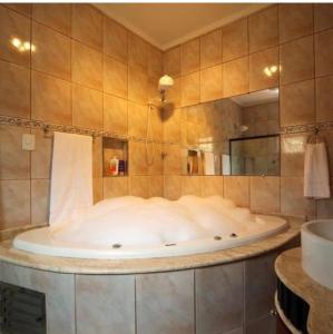 a large tub in a bathroom with a mirror at Hotel ITR-SPA in Itupeva