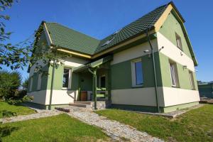 Casa verde y blanca con techo verde en Pokoje Gościnne Butryny, en Butryny