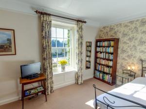 a bedroom with a bed and a window and a tv at Manor Farm B&B in Marlborough