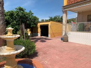 a brick patio with a fountain in front of a house at Villa Barby in Lliria