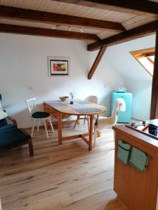 a kitchen and dining room with a wooden table at FW Mittschiffs, 1 Obergeschoss, Petershof-Lehbek in Gelting