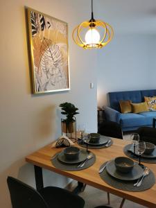 mesa de comedor con sillas negras y sofá azul en Apartament Zofia 2 Przy Plaży, en Władysławowo