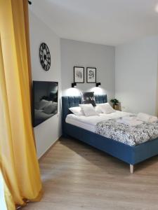 1 dormitorio con 1 cama y reloj en la pared en Apartament Zofia 2 Przy Plaży, en Władysławowo